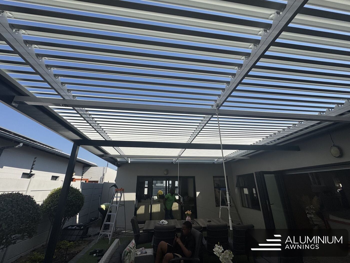 Charcoal-framed, white-louvred aluminium roof over a patio — Blouberg, Cape Town
